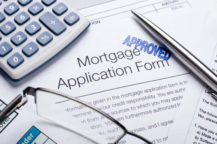 Approved Mortgage application form with a calculator and pen